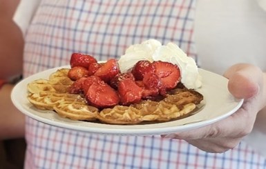 Frische Waffeln mit Erdbeeren und Sahne.