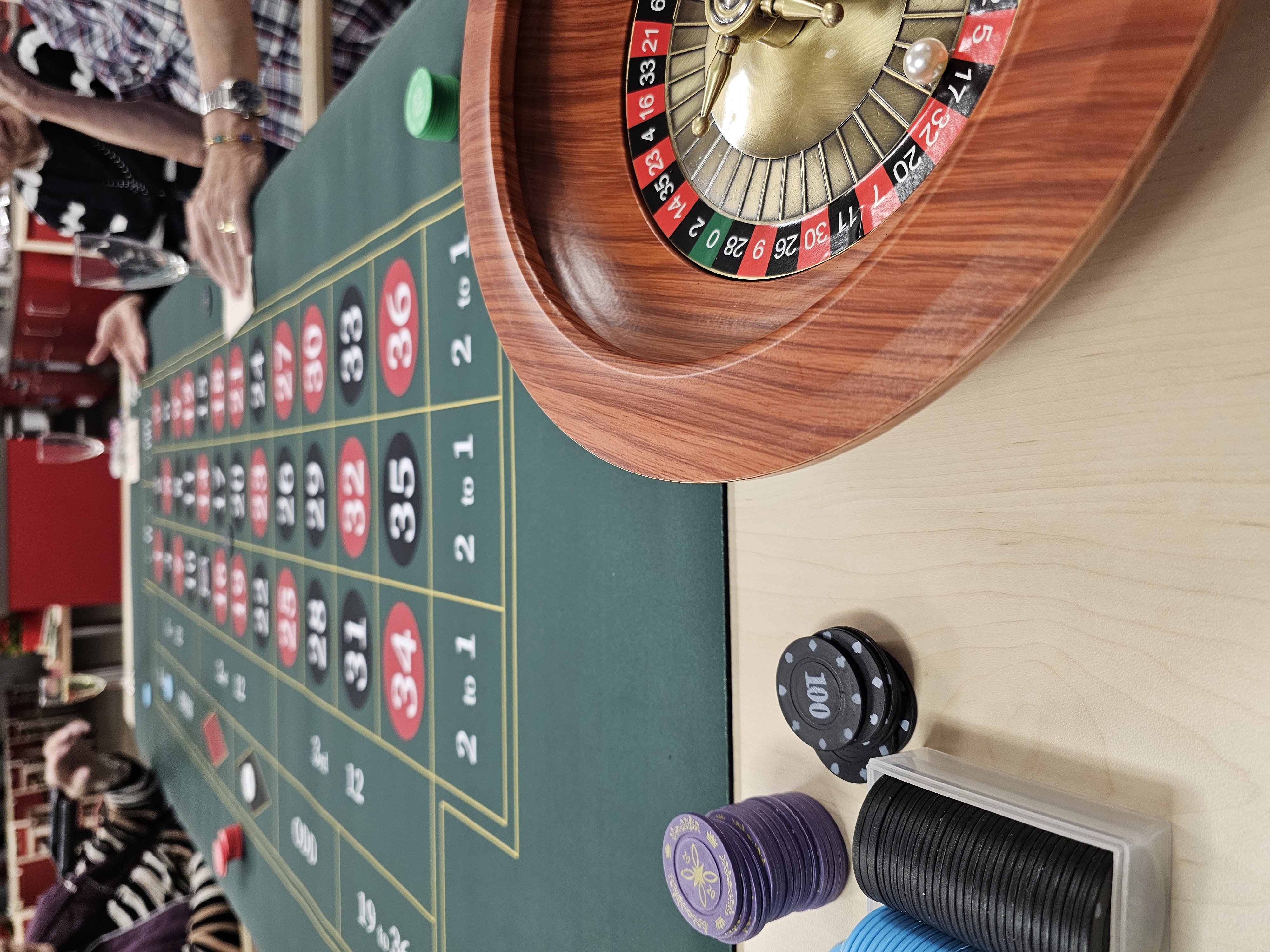 Dieses Bild zeigt einen Roulettisch mit Spielgeld und einem Glücksrad.